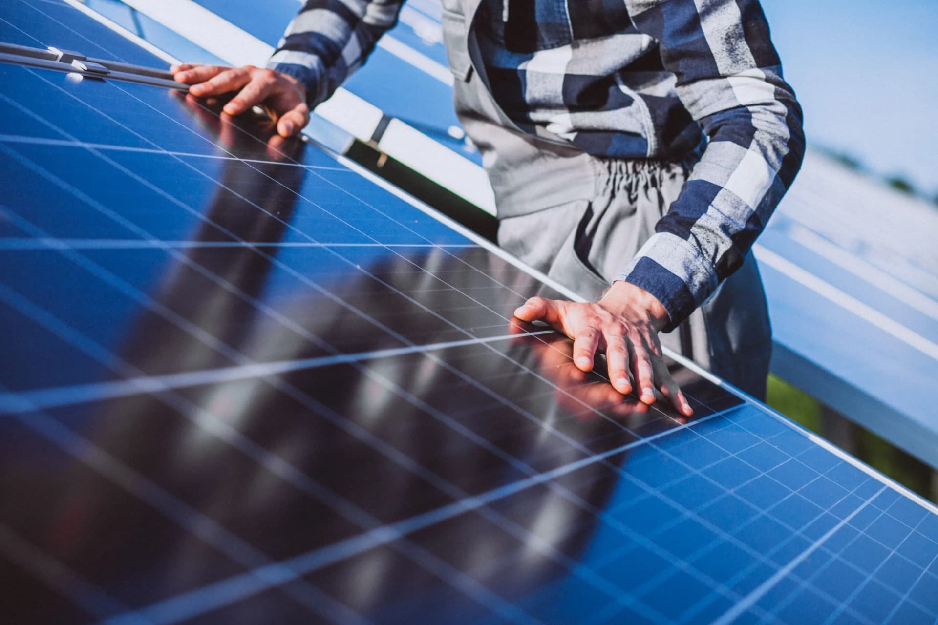 Fachkundiger Photovoltaik Monteur bei der Installation von Solarmodulen auf dem Dach